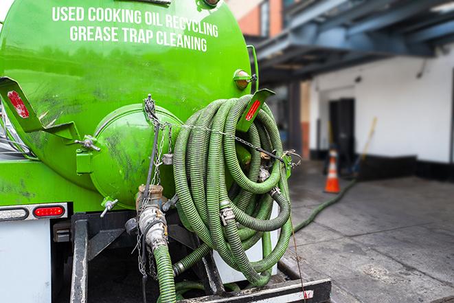 a professional technician pumping a restaurant's grease trap in Arlington, WA